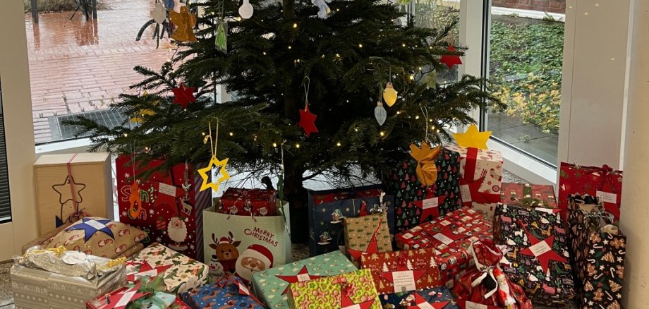 Ein geschmückter Tannenbaum mit schön verpackten Geschenken darunter