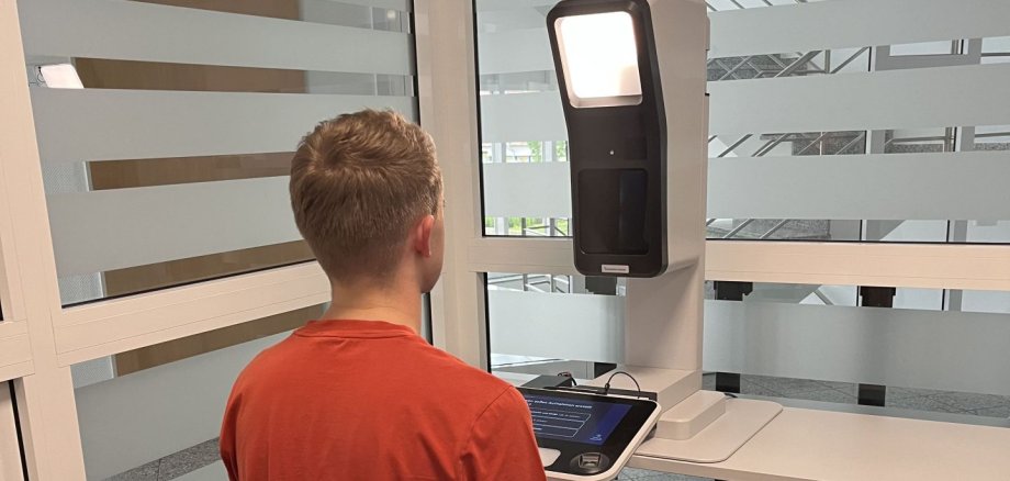 Ein Bürger sitzt zur Erstellung eines digitalen Passfoto vor der Kamera