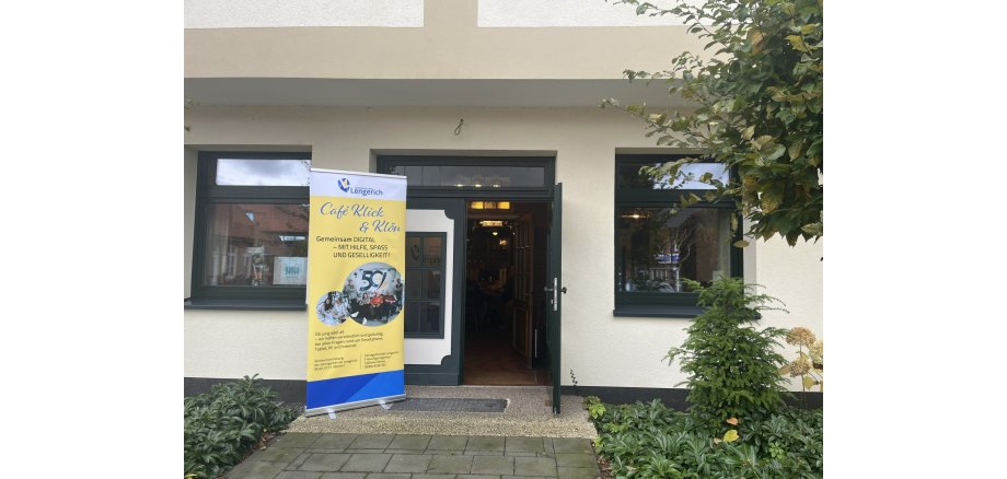Haus Erdmann mit Roll-Up Digitalcafé davor