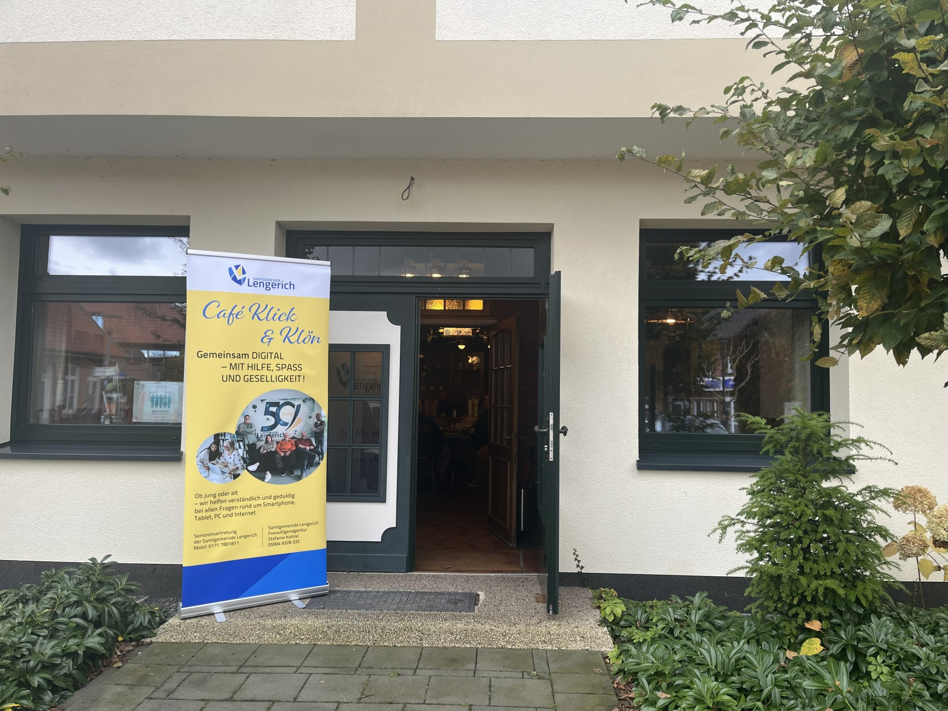 Haus Erdmann mit Roll-Up Digitalcafé davor
