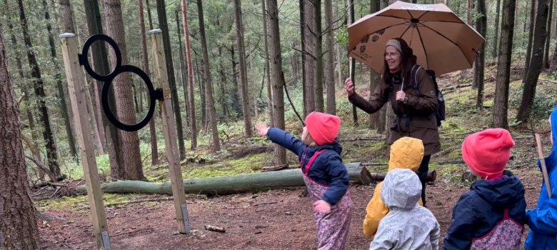 Die Kinder werfen mit Jutta Over Sachen durch aufgestellte Ringe