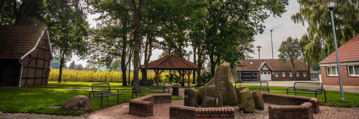 Blick auf einen Springbrunnen aus verschiedenen Steinen  die für alle Ortsteile von Langen stehen. 