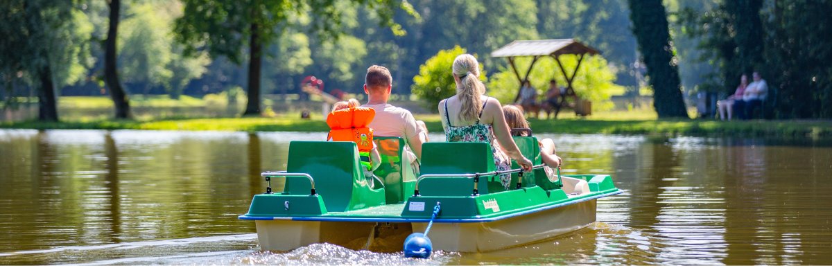 Eine Familie fährt Tretboot auf dem Saller See