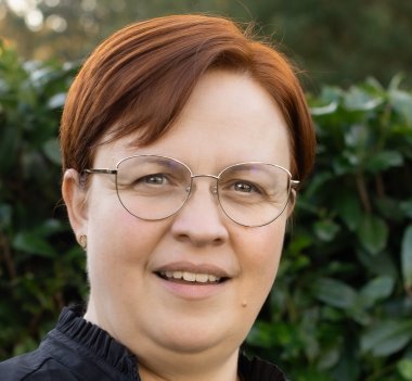 Die Gleichstellungsbeauftragte Kathrin Robbe lächelnd im Garten  