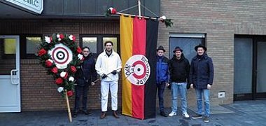 Auf dem Foto sind vom Schieben schaiten in Wettrup der Pajaz mit Peitsche Tom Buitmann links der Fahne und Fähnrich Michael Mers rechts der Fahne zu sehen