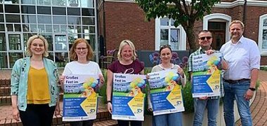 Das Orga-Team mit Plakat wirbt für das Große Fest im kleinen Park am  ersten und zweiten Juni zweitausendvierundzwandzig in Handrup